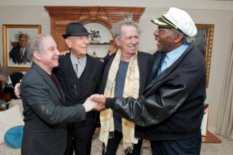 Paul Simon, Leonard Cohen, Keith Richards and Chuck Berry huddle together.