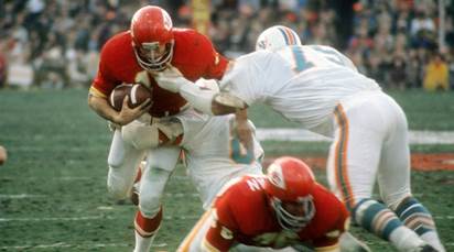 Ed Podolak is tackled by Dophins LB Nick Buoniconti and DT Manny Fernandez.