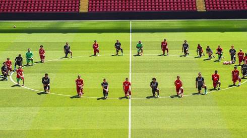 Liverpool players kneel down at Anfield in tribute to George Floyd