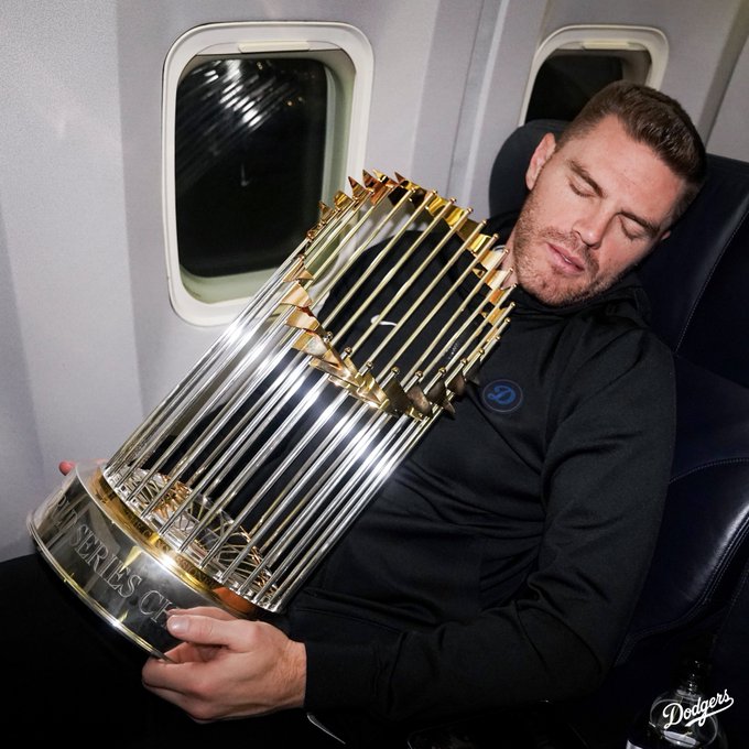 Freddie Freeman sleeps while holding the World Series trophy.